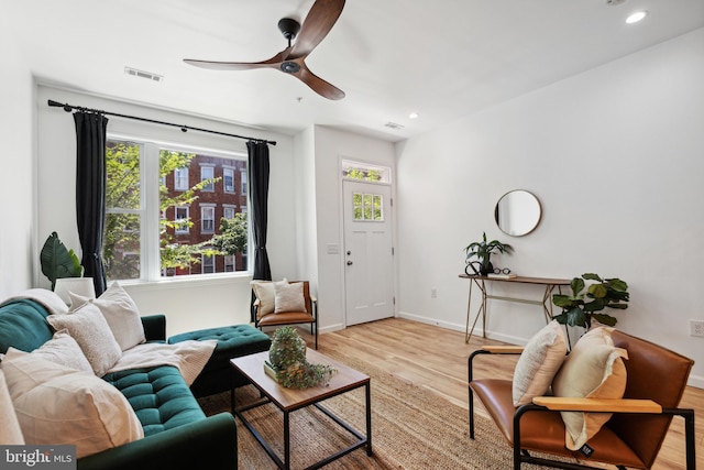 living room featuring ceiling fan, light hardwood / wood-style floors, and a wealth of natural light