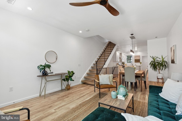 living room with ceiling fan and light hardwood / wood-style flooring