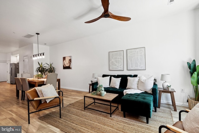 living room with light hardwood / wood-style flooring and ceiling fan