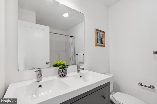 bathroom featuring a shower with curtain, vanity, and toilet