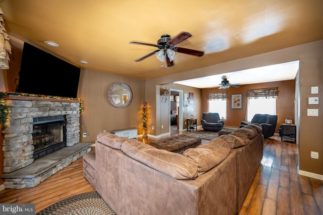 living room featuring ceiling fan, a fireplace, and hardwood / wood-style floors