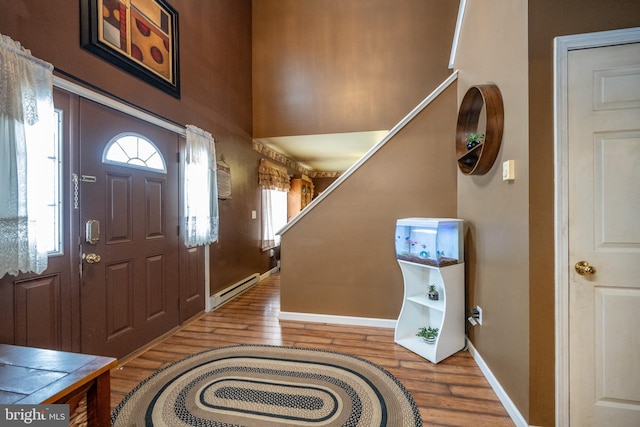 foyer with a baseboard heating unit and wood-type flooring