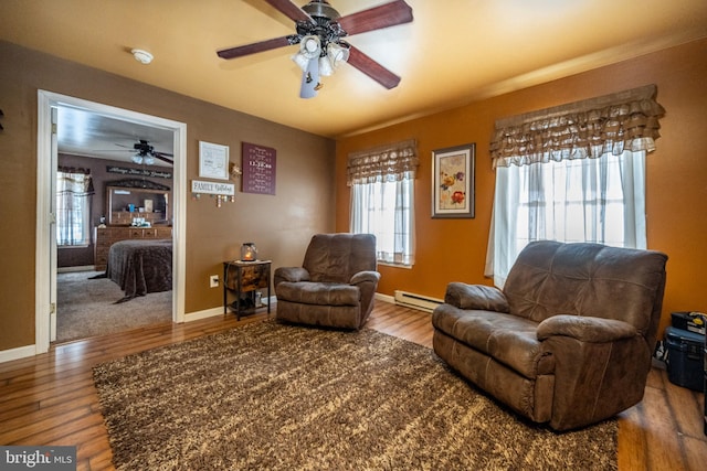 sitting room with a baseboard heating unit, ceiling fan, and hardwood / wood-style flooring