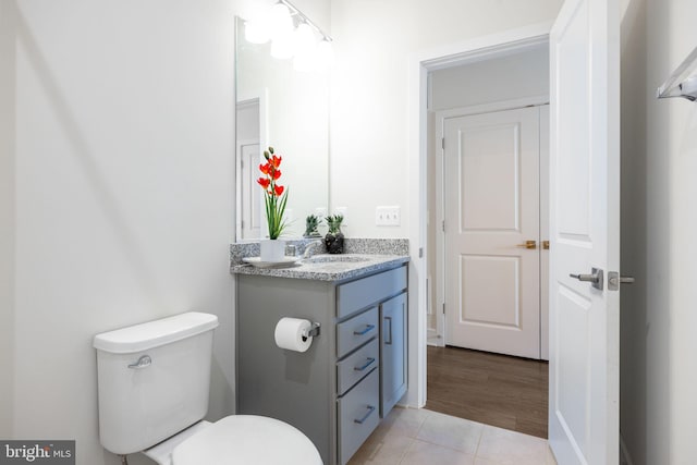 bathroom featuring toilet, vanity, and tile patterned flooring