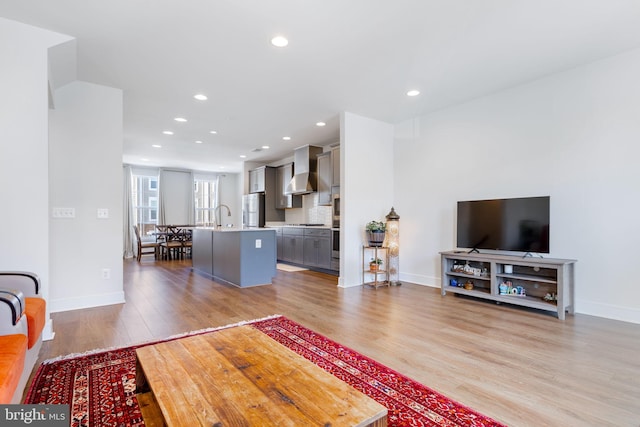 living room featuring light wood-type flooring and sink