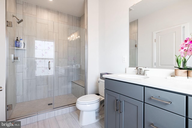 bathroom with tile patterned flooring, toilet, vanity, and walk in shower