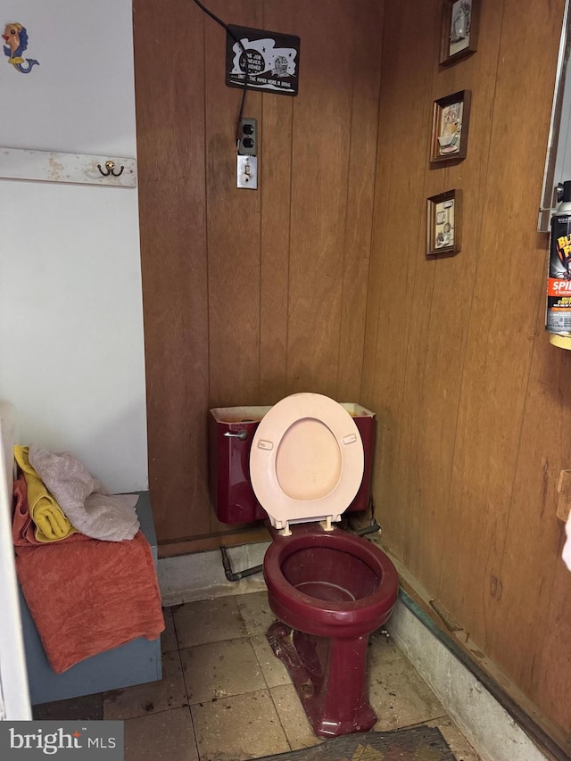 bathroom with wooden walls and toilet