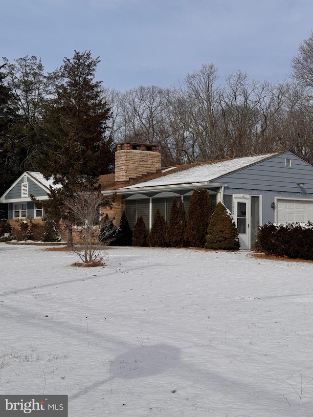 snow covered property featuring a garage