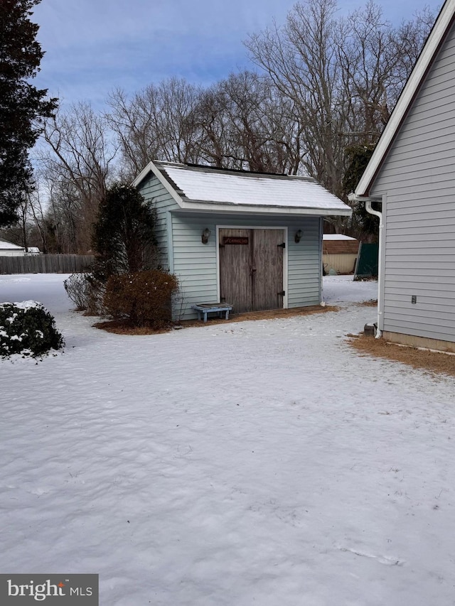 snow covered property with an outbuilding