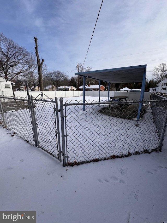 yard layered in snow with a carport