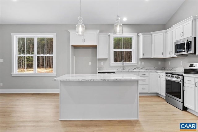 kitchen with stainless steel appliances, white cabinetry, hanging light fixtures, and a center island