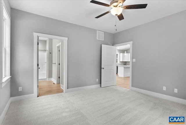 unfurnished bedroom with ceiling fan and light colored carpet