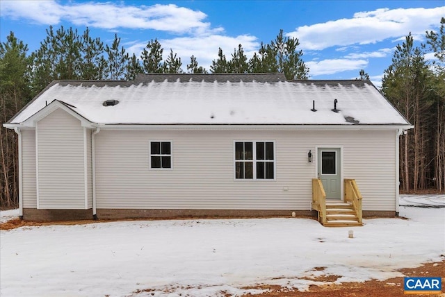 view of snow covered rear of property