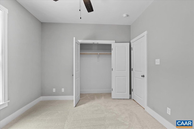 unfurnished bedroom featuring ceiling fan, a closet, and light carpet