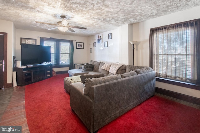 living room with ceiling fan, dark wood-type flooring, and a textured ceiling