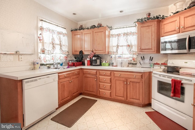 kitchen featuring sink, white appliances, and ornamental molding