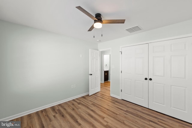 unfurnished bedroom with wood-type flooring, ceiling fan, and a closet