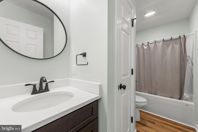 full bathroom with hardwood / wood-style flooring, vanity, shower / bathtub combination with curtain, and toilet