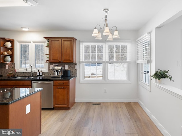 kitchen with stainless steel dishwasher, a healthy amount of sunlight, decorative backsplash, and a chandelier