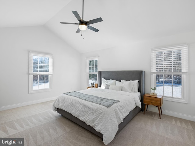 carpeted bedroom with ceiling fan, multiple windows, and vaulted ceiling