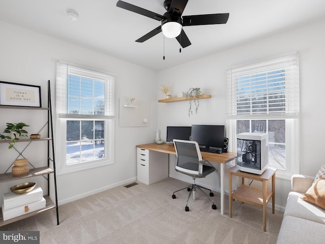 home office featuring light carpet, ceiling fan, and a wealth of natural light