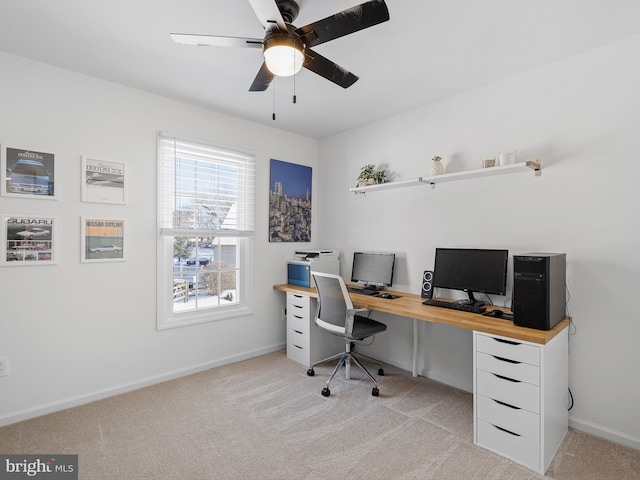 carpeted home office featuring ceiling fan