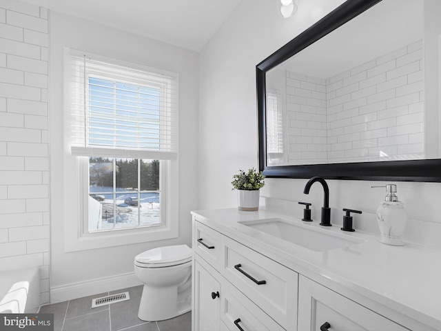 bathroom with toilet, tile patterned flooring, and vanity