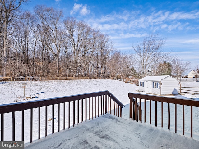 snow covered deck featuring an outdoor structure