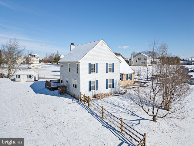 snow covered rear of property with a wooden deck