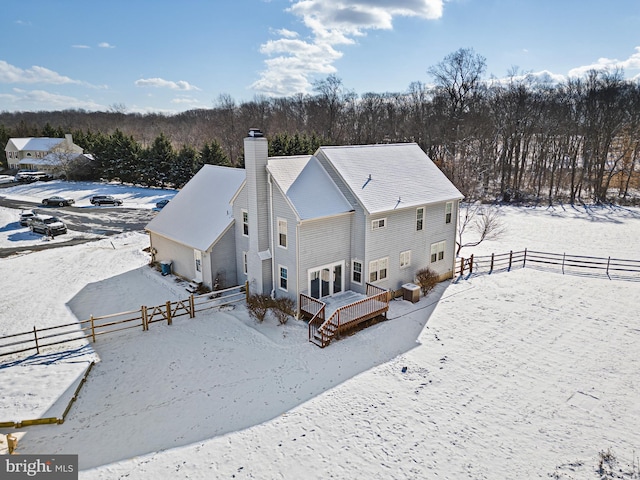 view of snow covered back of property