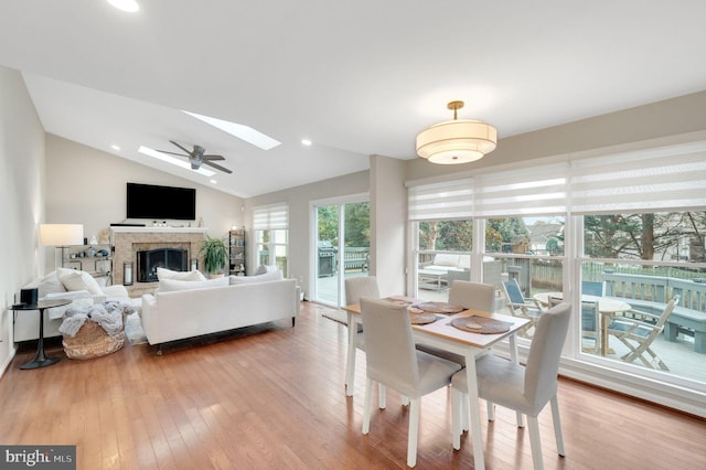 dining room featuring hardwood / wood-style flooring and vaulted ceiling with skylight