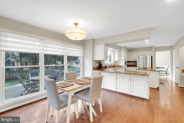 dining area with sink and light wood-type flooring