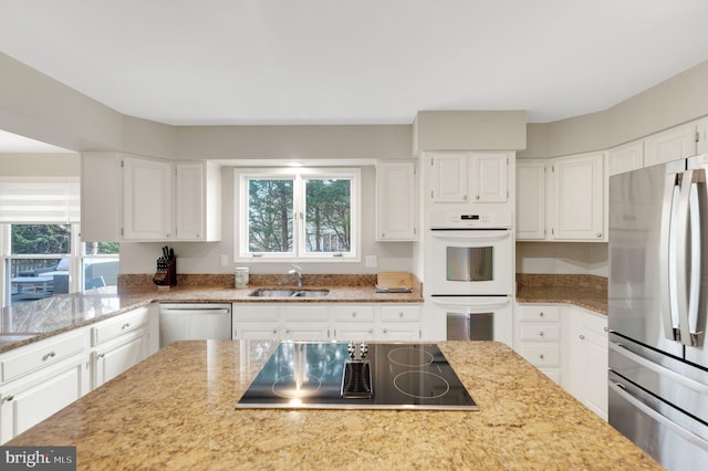 kitchen featuring stainless steel appliances, sink, and white cabinets