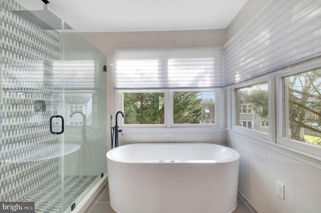 bathroom featuring plus walk in shower and plenty of natural light