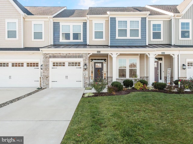 townhome / multi-family property featuring a front yard and a garage