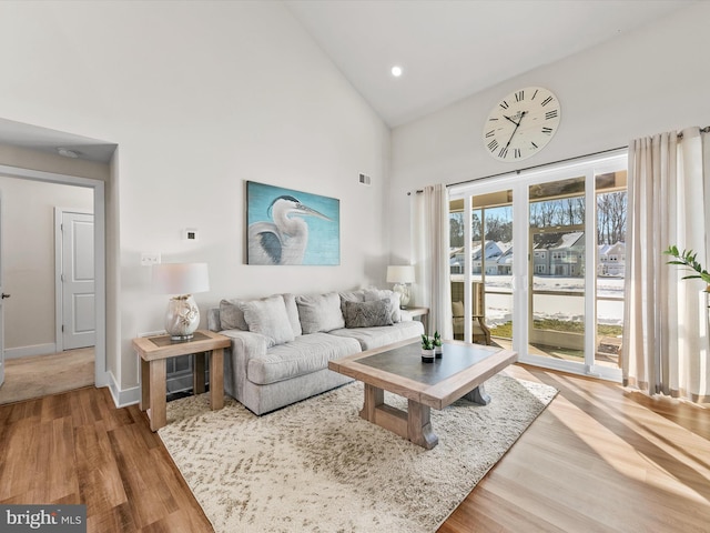 living room with high vaulted ceiling and hardwood / wood-style floors