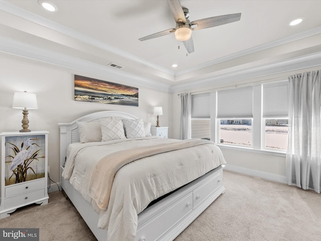 bedroom featuring ceiling fan, light carpet, a raised ceiling, and ornamental molding