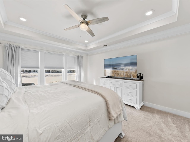 carpeted bedroom featuring ceiling fan, ornamental molding, and a tray ceiling