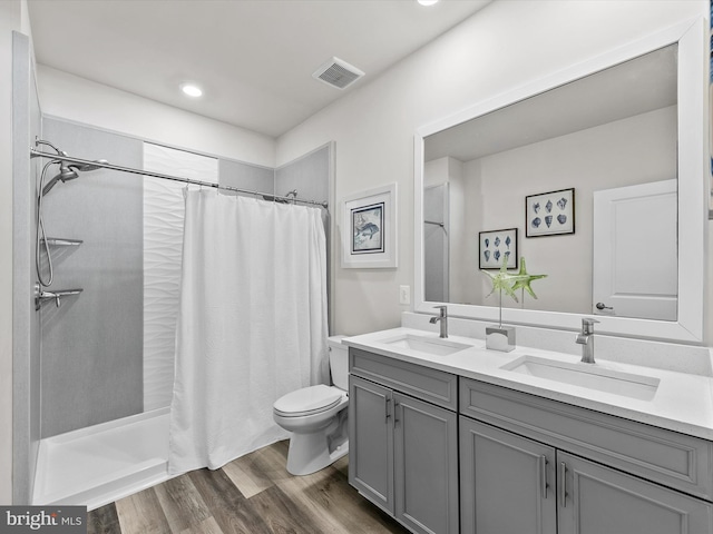 bathroom with hardwood / wood-style flooring, toilet, vanity, and a shower with curtain