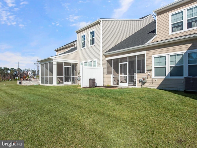 rear view of property with cooling unit, a lawn, and a sunroom