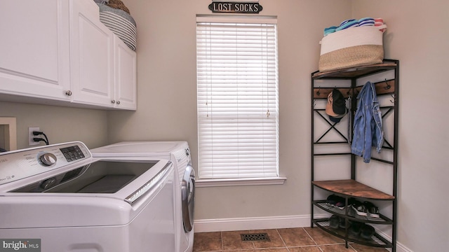 washroom with dark tile patterned flooring, separate washer and dryer, and cabinets