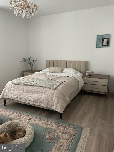 bedroom featuring dark hardwood / wood-style floors and a notable chandelier