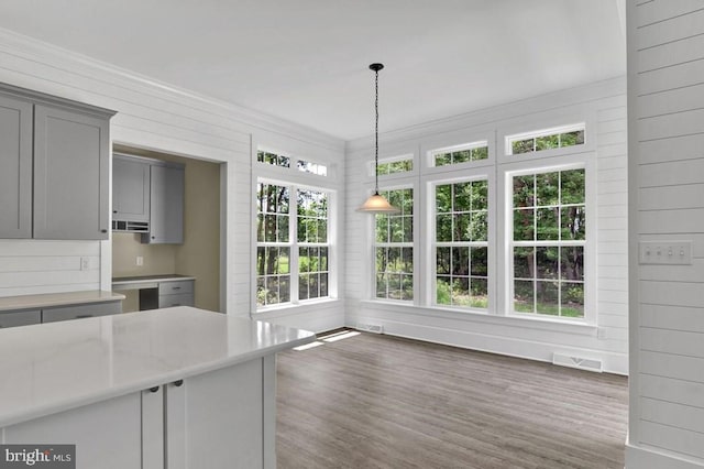 kitchen featuring pendant lighting, dark hardwood / wood-style floors, gray cabinetry, and crown molding