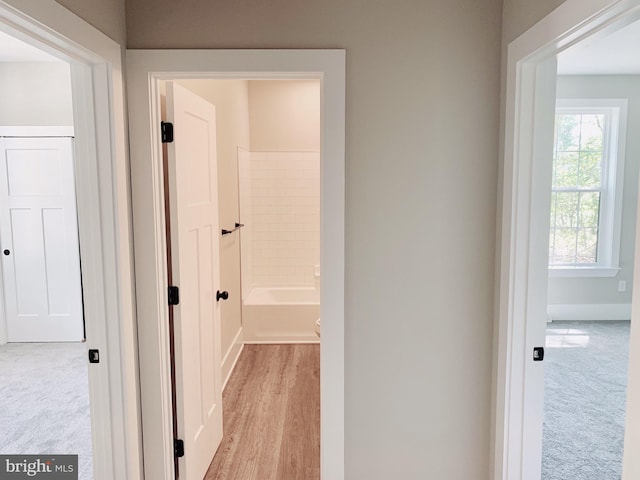 hallway with light colored carpet