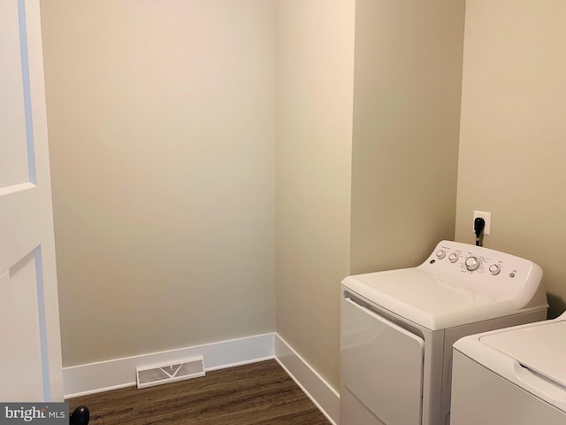 laundry room with washing machine and dryer and dark hardwood / wood-style flooring