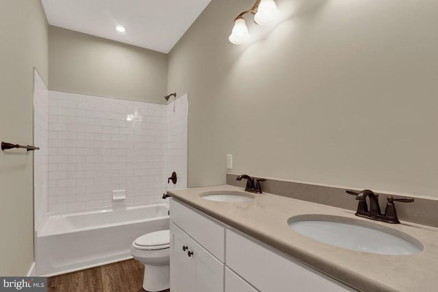 full bathroom with toilet,  shower combination, hardwood / wood-style flooring, and vanity