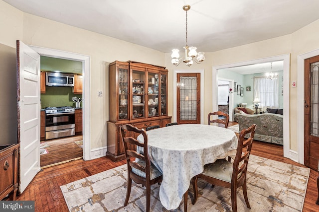 dining space with hardwood / wood-style flooring and a notable chandelier