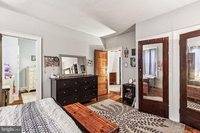 bedroom with hardwood / wood-style flooring and ensuite bathroom