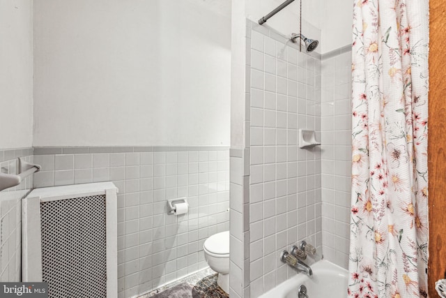 bathroom featuring tile walls, toilet, and shower / bath combination with curtain