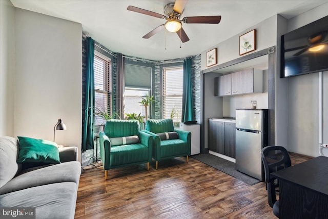 living room featuring ceiling fan and dark hardwood / wood-style flooring